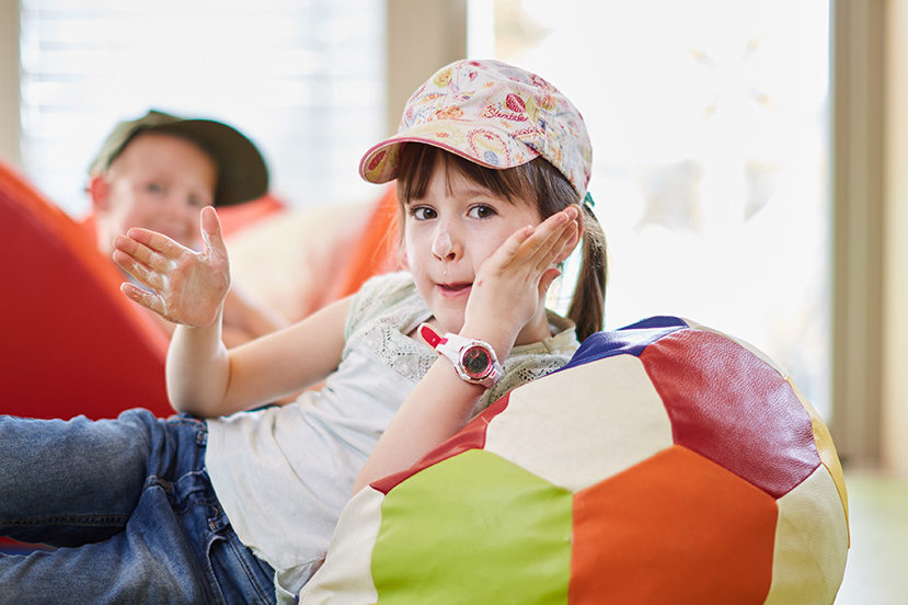 Ein Mädchen schmiert sich gerade das Gesicht mit Sonnencreme ein.