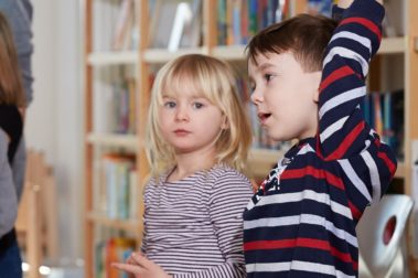 Ein Mädchen und ein Junge aus der Vorschulklasse besuchen die Grundschule und stellen Fragen.