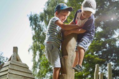 Zwei Jungen klettern an einem Kletterbaum.