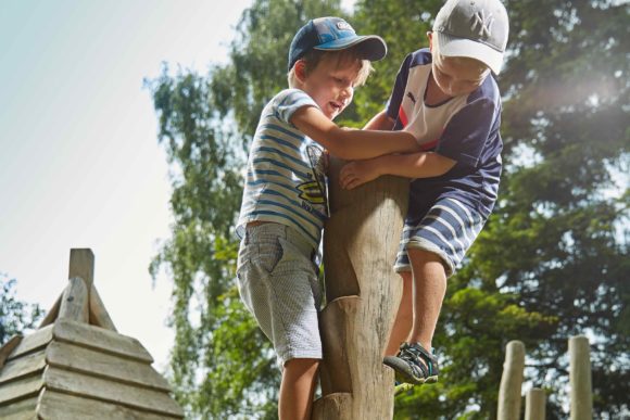 Zwei Jungen klettern an einem Kletterbaum.