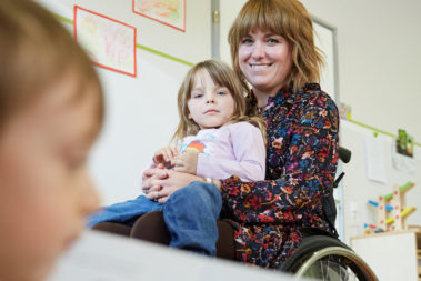 Portrait von Daniela Koffmane. Sie ist Erzieherin in der Protestantischen Kindertagesstätte Turnerstraße in Kaiserslautern und sitzt im Rollstuhl.