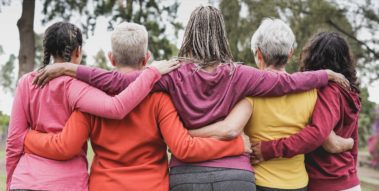Fünf Frauen unterschiedlichen Alters bilden eine Kette.