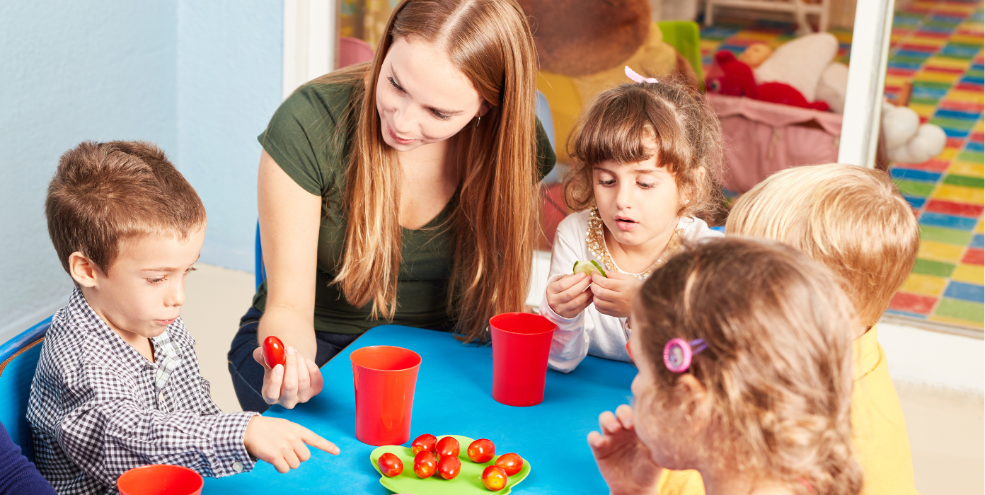 Erzieherin mit Kindern beim Essen