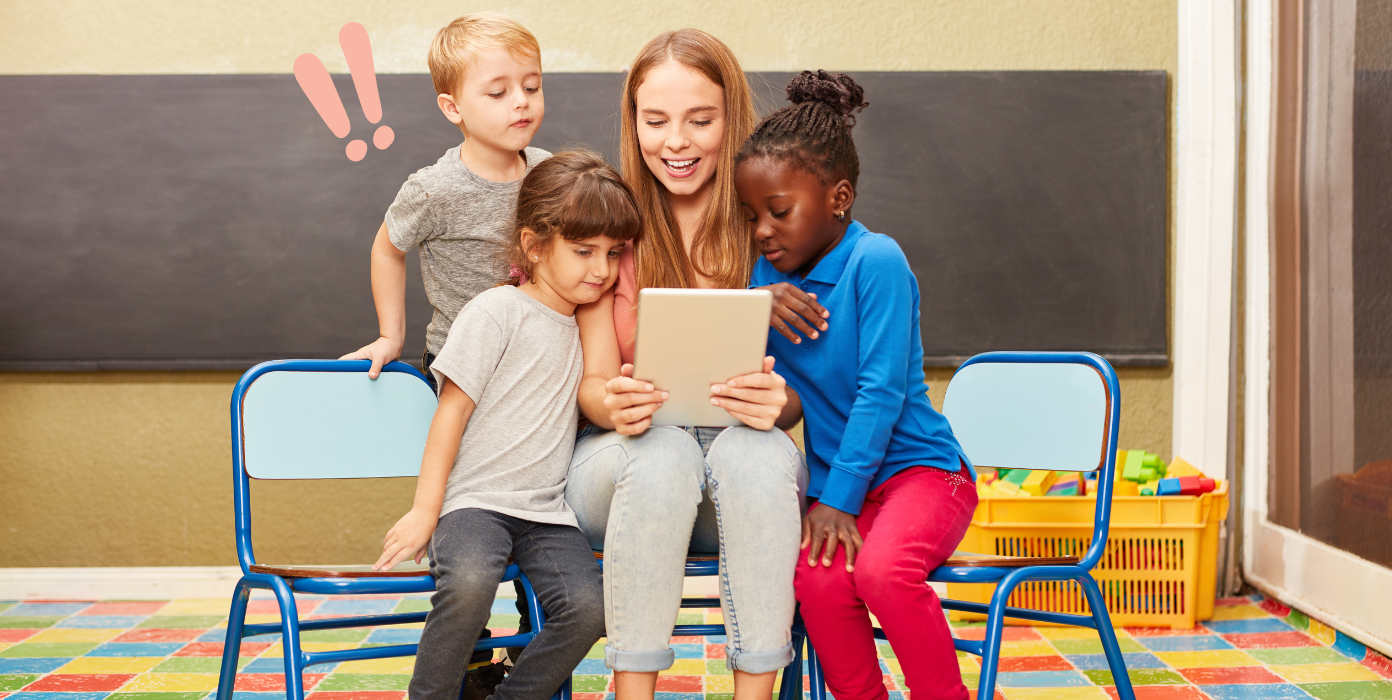 Erzieherin in der Kita betrachtet mit Kindern ein Tablet