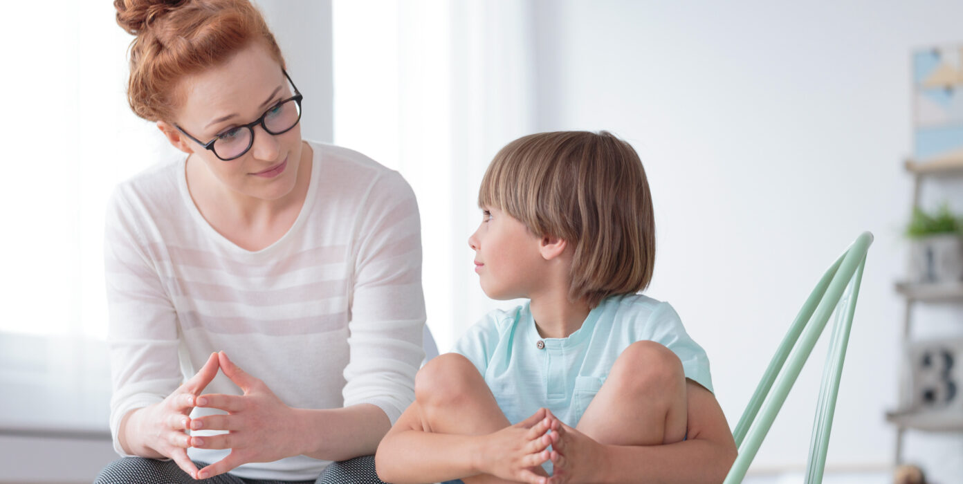 Erzieherin spricht mit Kind