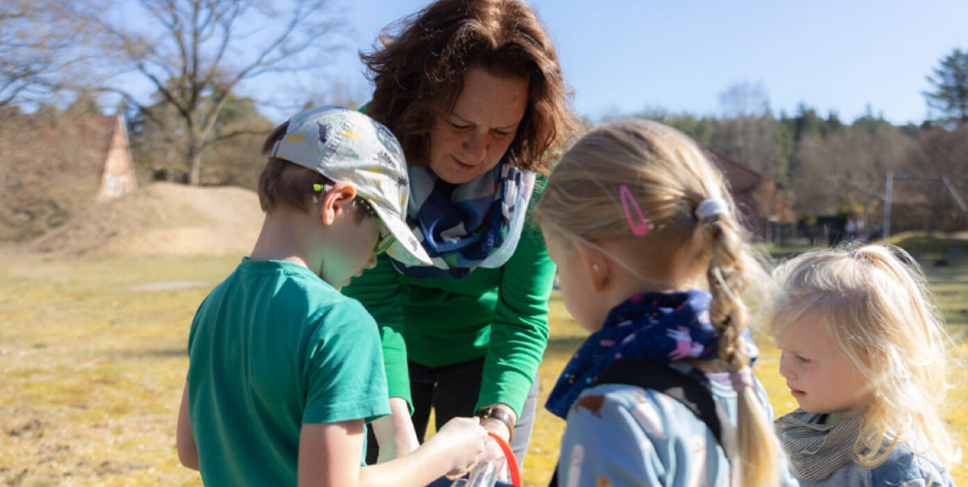 Sabine Pöhler schaut in die Eimer von drei Kindern.