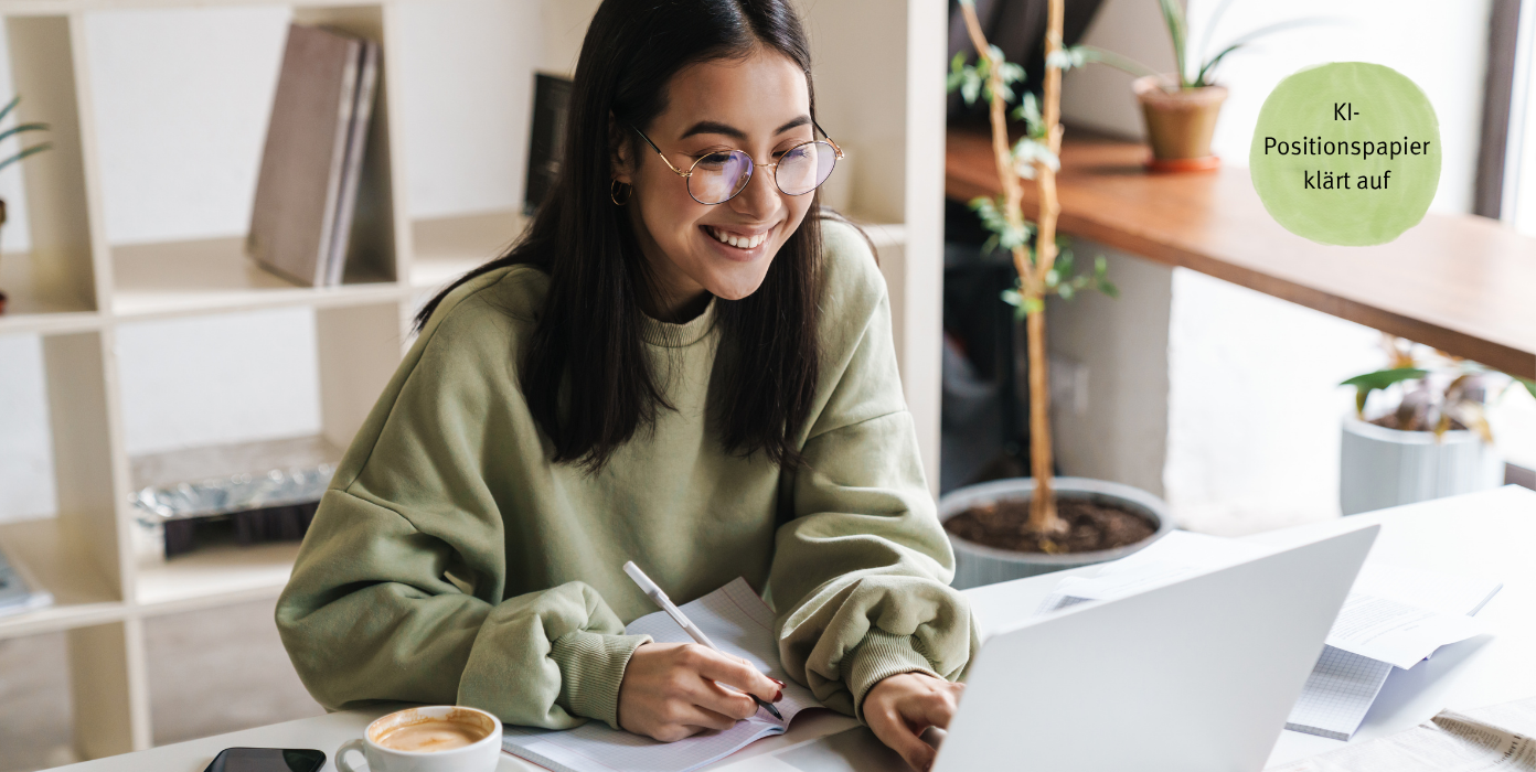 Junge Frau lächelnd am Computer am Schreibtisch